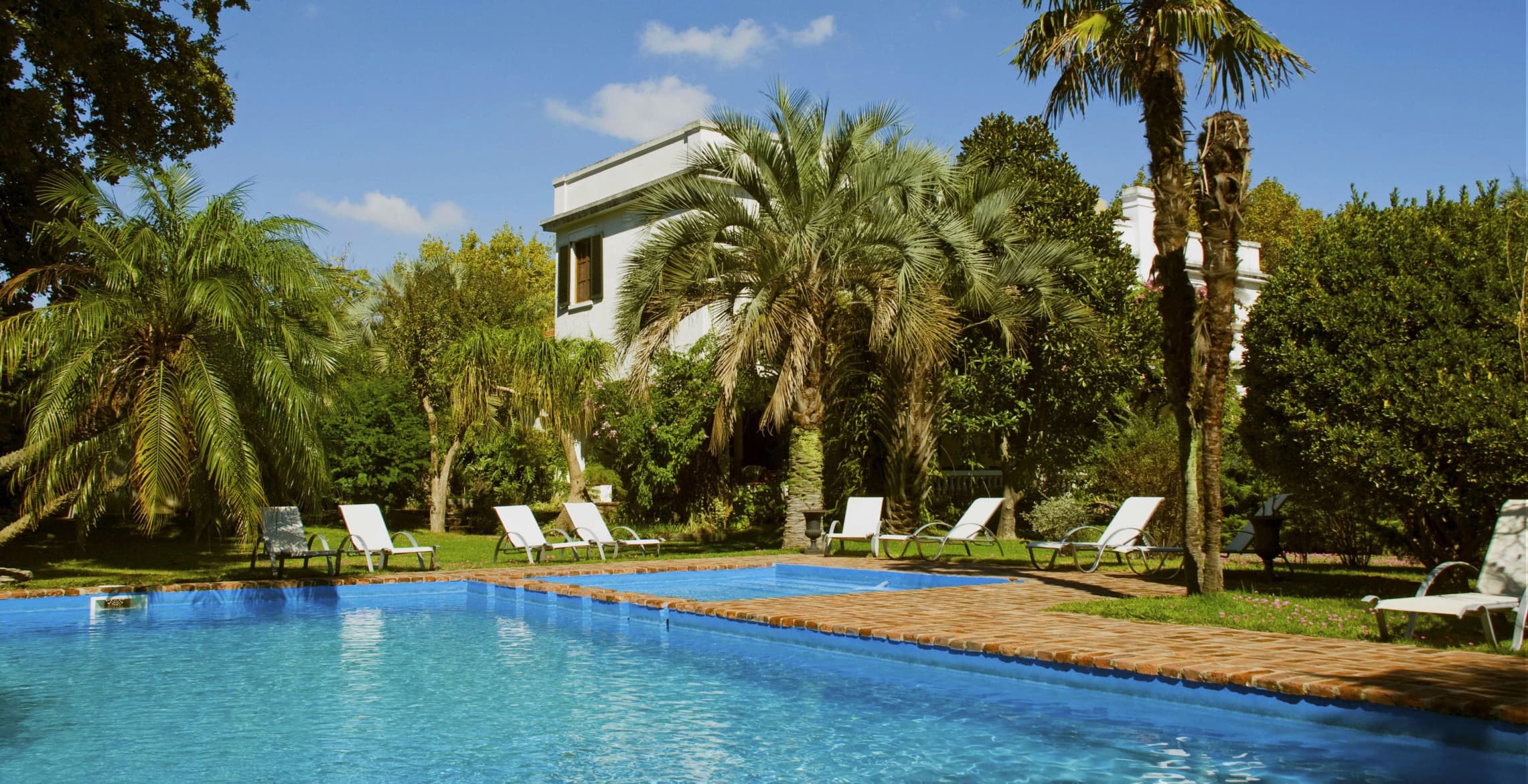 Piscina y jardín centenario del Hotel Villa Victoria