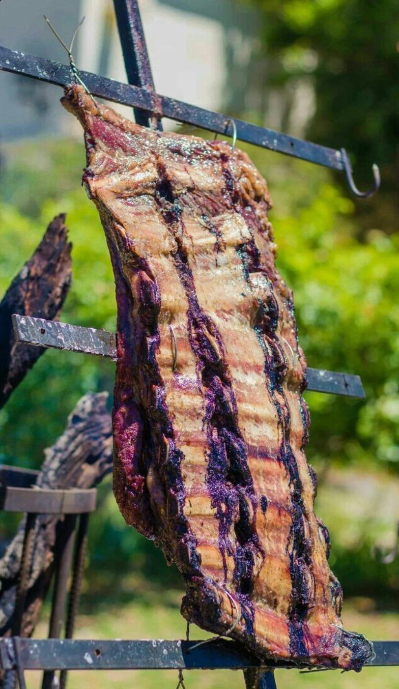 Costillar a la estaca dorándose sobre el fuego