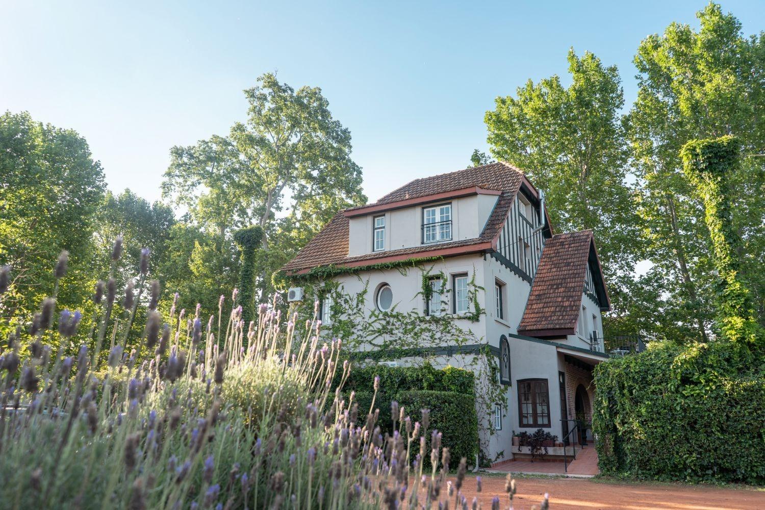 La segunda casona entre árboles, con lavanda en primer plano