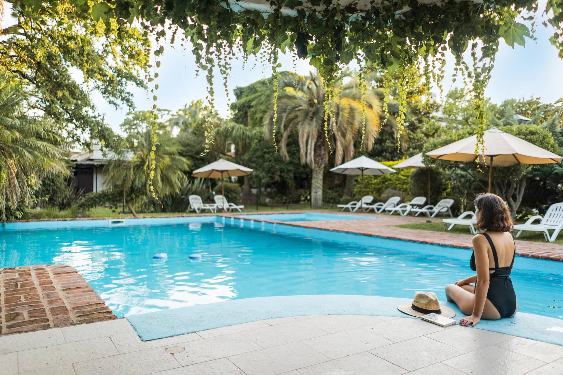 Huésped junto a la piscina entre palmeras