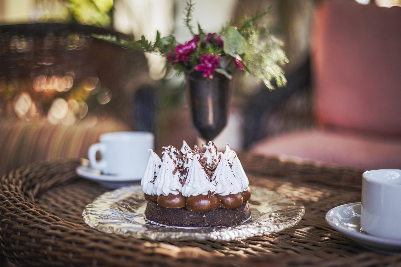 Torta casera con merengue sobre una mesa de mimbre
